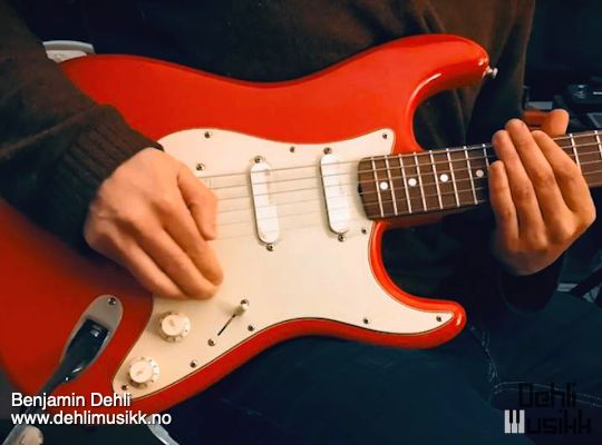 A red Fender Stratocaster being played